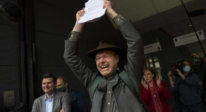 Milieudefensie director Donald Pols, holding a copy of the verdict, celebrates the outcome in the court case of Milieudefensie, the Dutch arm of the Friends of the Earth environmental organization, ag ...