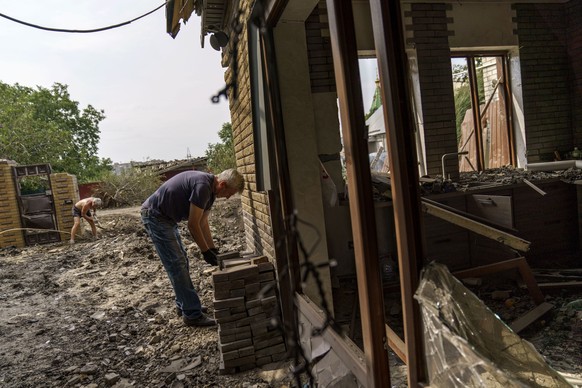 Volodymyr Parshyn cleans up debris from a rocket strike on his son's home in Kramatorsk, Donetsk region, eastern Ukraine, Friday, Aug. 12, 2022. &quot;I don't know for how long Putin will terrorize us,&quot; said Parshyn. There were no injuries reported in the strike. (AP Photo/David Goldman)