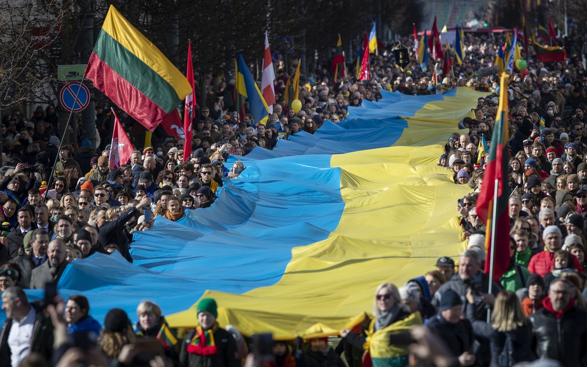People carry a giant Ukrainian flag to protest against the Russian invasion of Ukraine during a celebration of Lithuania's independence in Vilnius, Lithuania, Friday, March 11, 2022. Lithuania ce ...