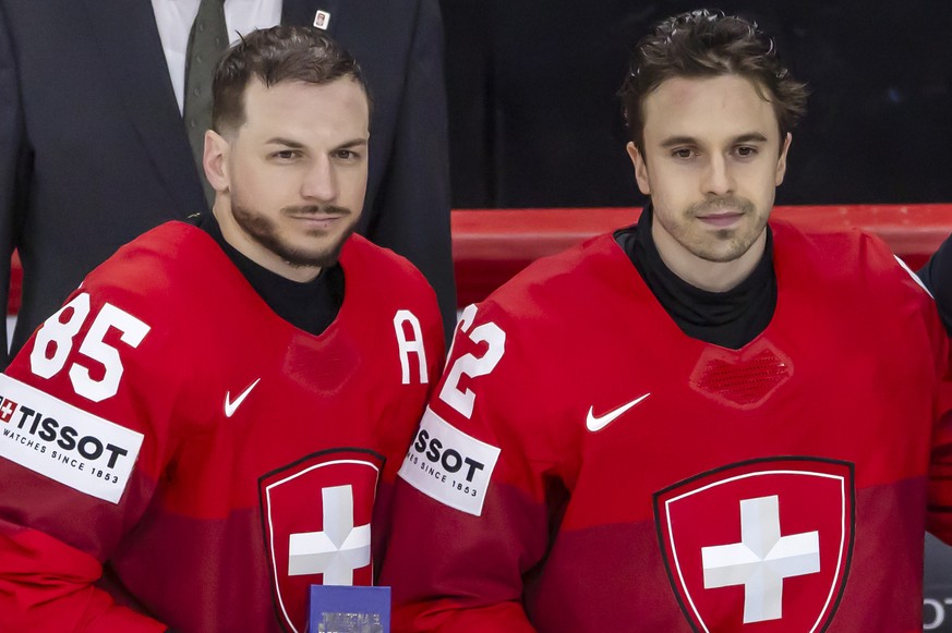 Best Swiss players of the tournament - forward Sven Andrighetto #85, forward Denis Malgin #62 and goaltender Leonardo Genoni #63 - pose with awards past Switzerland's Defense Minister Federal Cou ...