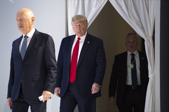 US President Donald Trump, center, and German Klaus Schwab, left, Founder and Executive Chairman of the World Economic Forum, WEF, arrives on stage before addressing a plenary session during to the 50 ...