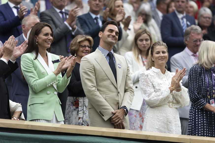 Roger Federer reacts beside Catherine, Princess of Wales, left, and his wife Mirka Federer, as he is honored in the royal box at the All England Lawn Tennis Championships in Wimbledon, London, Tuesday ...