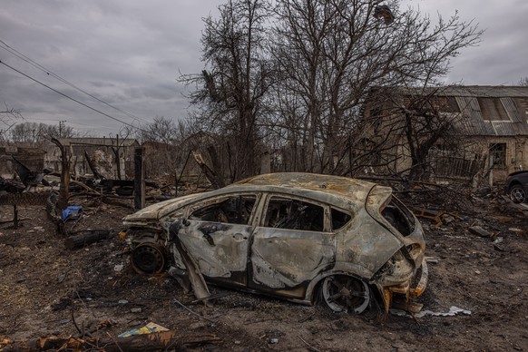 epa09874782 A burned car next to destroyed houses, in Bucha, the town which was retaken by the Ukrainian army, northwest of Kyiv, Ukraine, 06 April 2022. Hundreds of tortured and killed civilians have ...