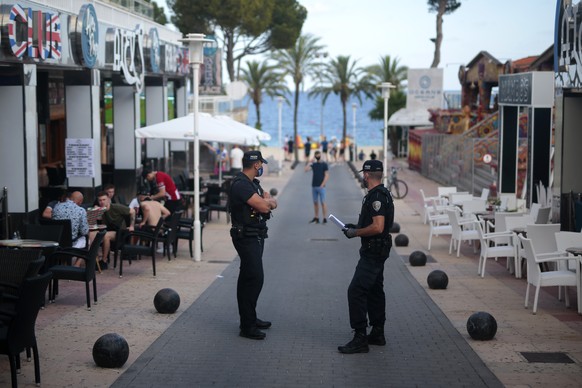 Police officers patrol at the resort of Magaluf on the Spanish Balearic island of Mallorca, Spain, Thursday, July 16, 2020. In a move designed to stop the spread of the new coronavirus and shake off t ...