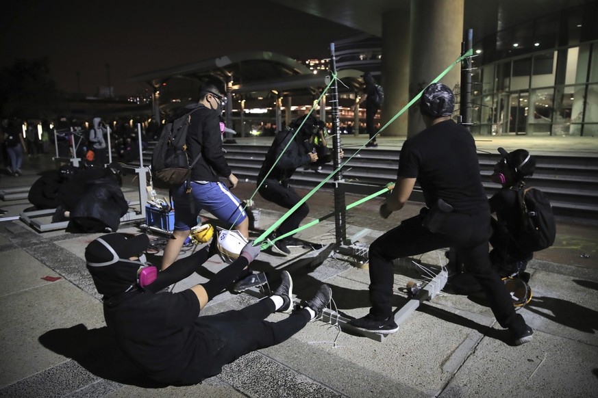 Protestors practice using a homemade slingshot at Hong Kong Polytechnic University in Hong Kong, Thursday, Nov. 14, 2019. Hong Kong police warned protesters on Thursday that they were moving &quot;one ...