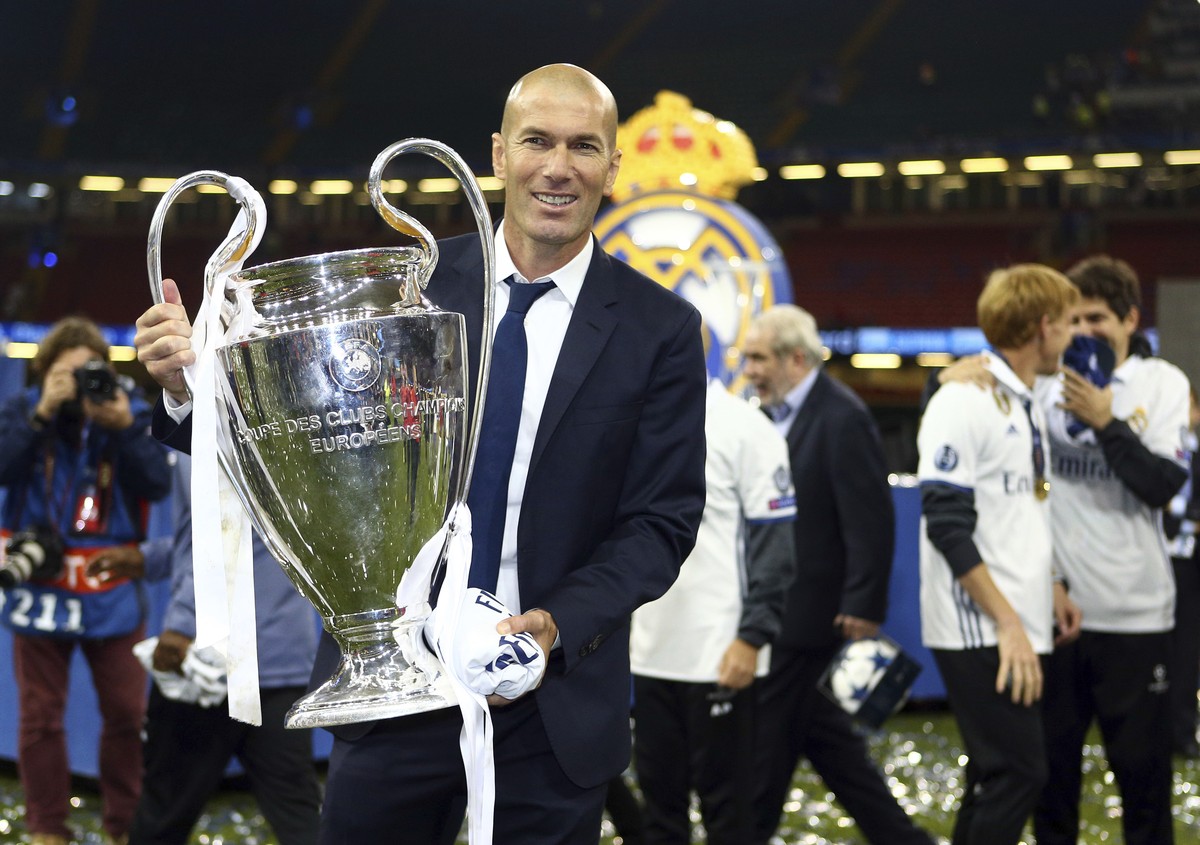Real Madrid's head coach Zinedine Zidane celebrates with the trophy at the end of the Champions League soccer final between Juventus and Real Madrid at the Millennium Stadium in Cardiff, Wales, S ...