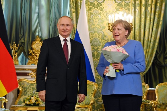 German Chancellor Angela Merkel, right, and Russian President Vladimir Putin smile during their meeting in the Kremlin in Moscow, Russia, Friday, Aug. 20, 2021. The talks between Merkel and Putin are  ...