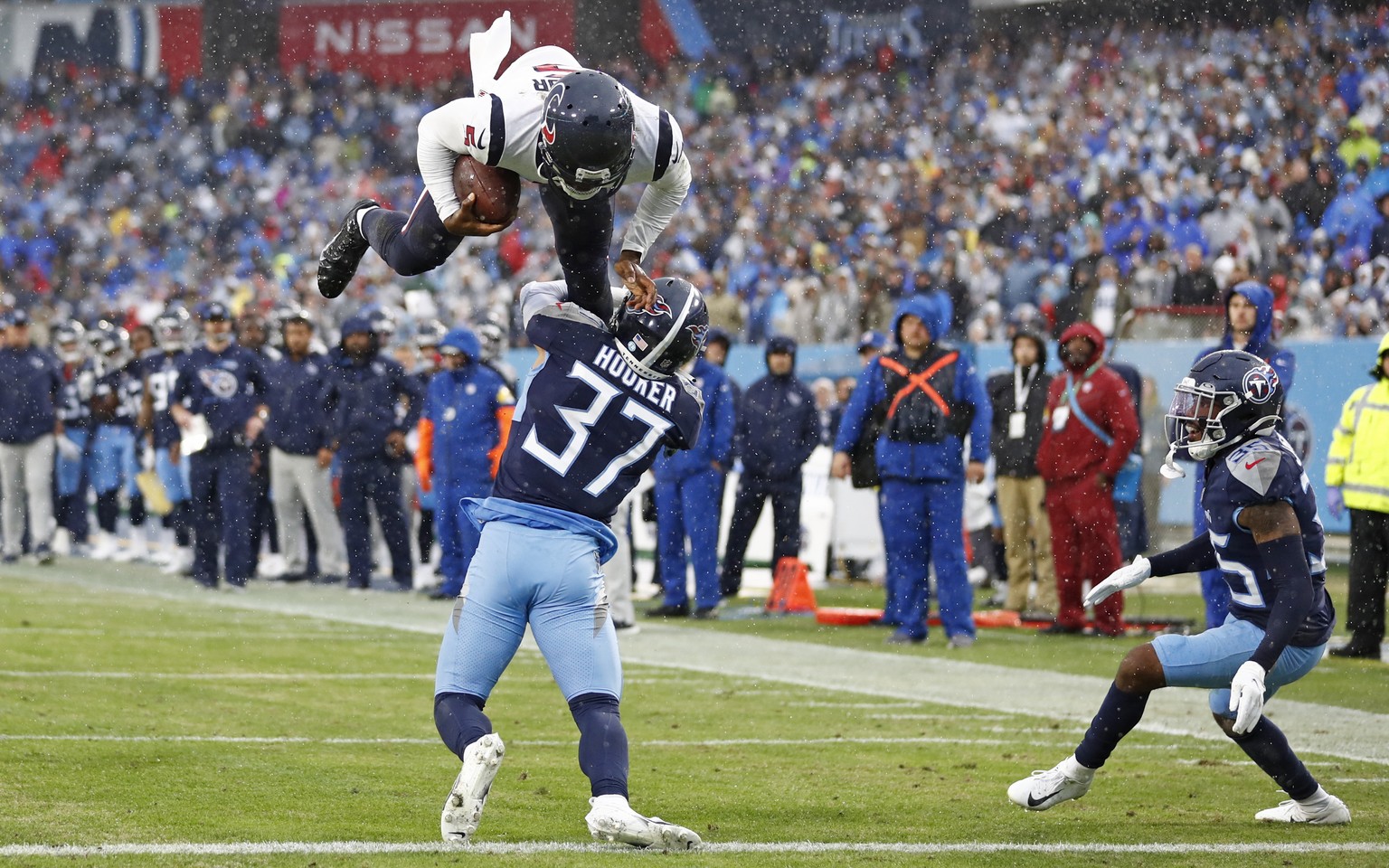 Houston Texans quarterback Tyrod Taylor, top, leaps over Tennessee Titans safety Amani Hooker (37) for a touchdown in the first half of an NFL football game Sunday, Nov. 21, 2021, in Nashville, Tenn.  ...