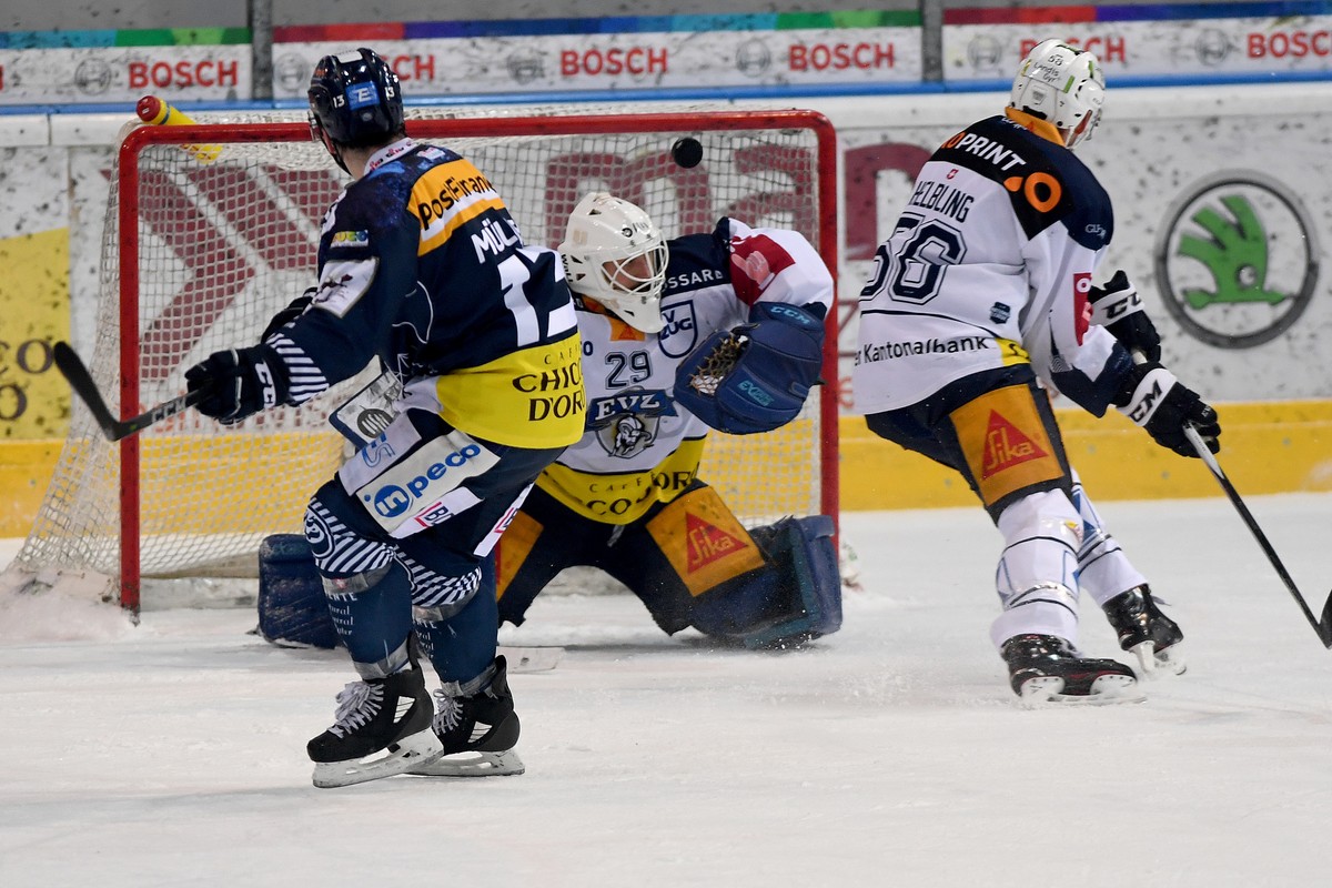 From left, Ambri's player Marco Mueller, Zug's goalkeeper Sandro Aeschlimann and Zug's player Timo Helbling, during the preliminary, round game of National League A (NLA, LNA) Swiss Cha ...