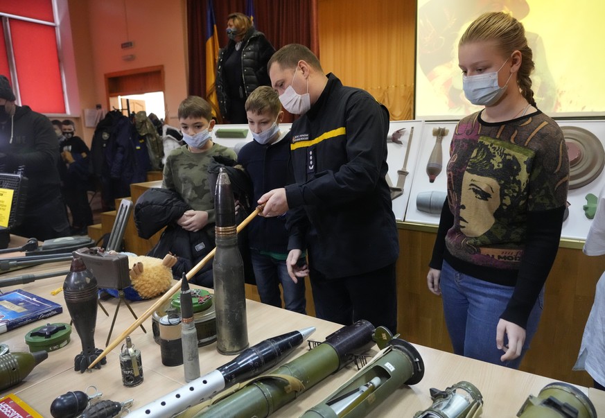 A police officer shows explosives to schoolchildren during a police-organized civilian safety lesson in a city school in Kyiv, Ukraine, Thursday, Jan. 27, 2022. The city authorities have launches trai ...