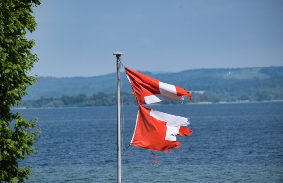 Am Bodensee, zerfetzte Schweizer Fahne im Wind