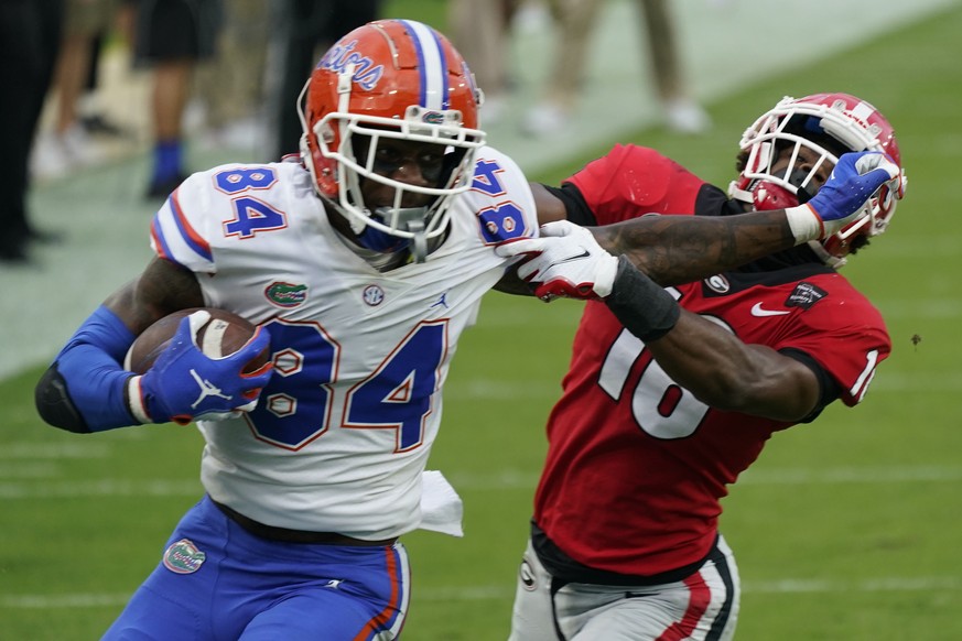 FILE - Florida tight end Kyle Pitts (84) tires to get past Georgia defensive back Lewis Cine (16) after a reception during the first half of an NCAA college football game in Jacksonville, Fla., in thi ...