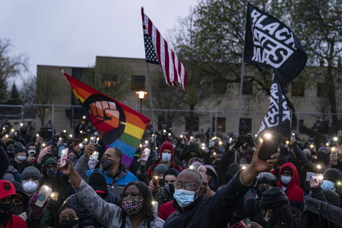 Demonstrators flash their mobile phone lights as they gather outside the Brooklyn Center Police Department to protest Sunday's fatal shooting of Daunte Wright during a traffic stop, Tuesday, Apri ...