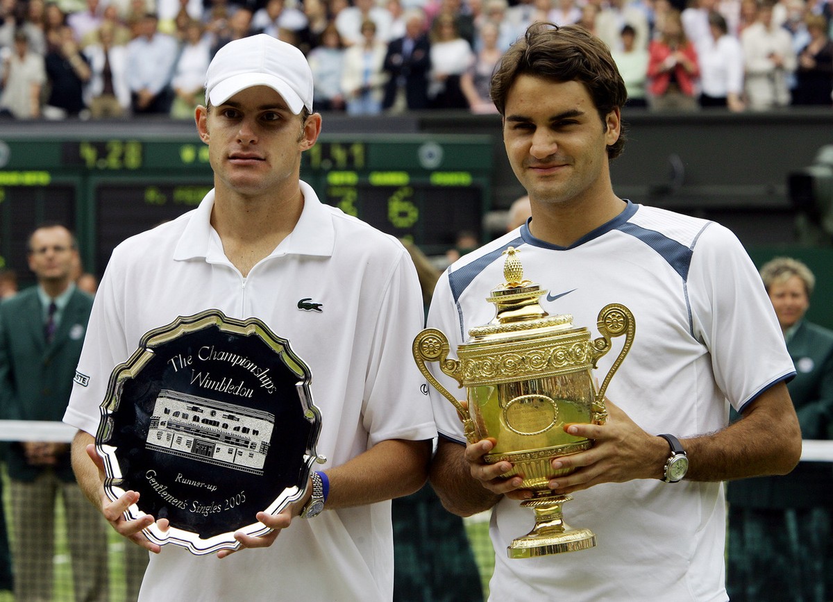 Roger Federer, of Switzerland, right, and Andy Roddick hold their trophies after Federer defeated Roddick 6-2, 7-6 (2), 6-4 to win the Mens' Singles Final on Centre Court at Wimbledon Sunday, Jul ...