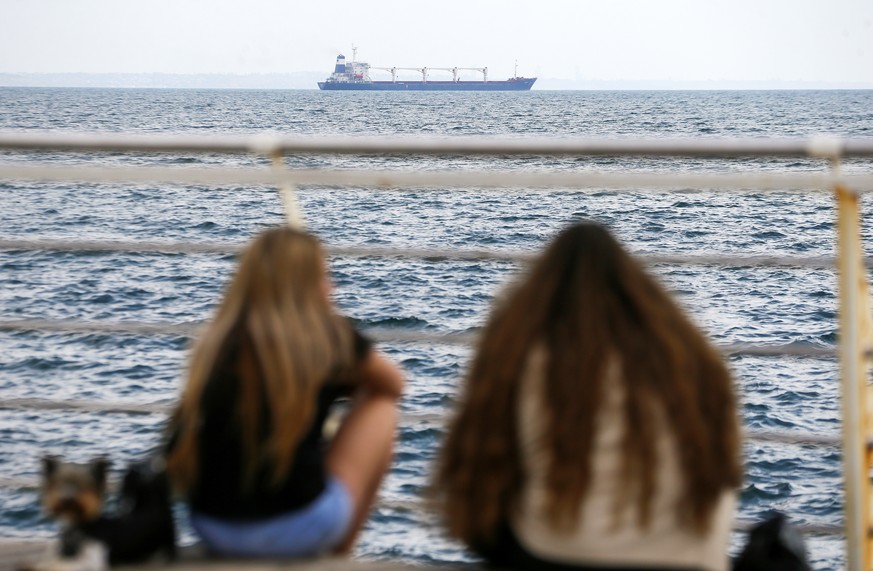 epaselect epa10101162 People watch Sierra Leone-flagged cargo ship &#039;Razoni&#039; leave the port of Odesa, Ukraine, 01 August 2022. The Razoni carries over 26,000 tons of corn and is bound for Tri ...