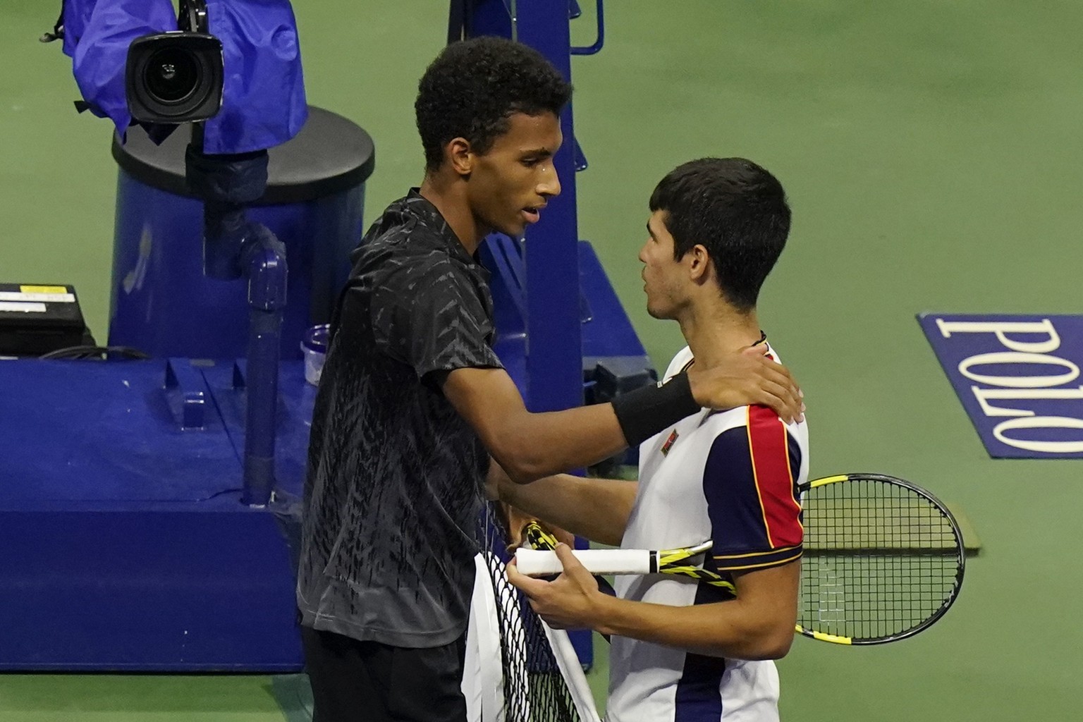 Felix Auger-Aliassime, of Canada, left, talks to Carlos Alcaraz, of Spain, after a quarterfinals match at the U.S. Open tennis tournament, Tuesday, Sept. 7, 2021, in New York. Alcaraz withdrew from th ...