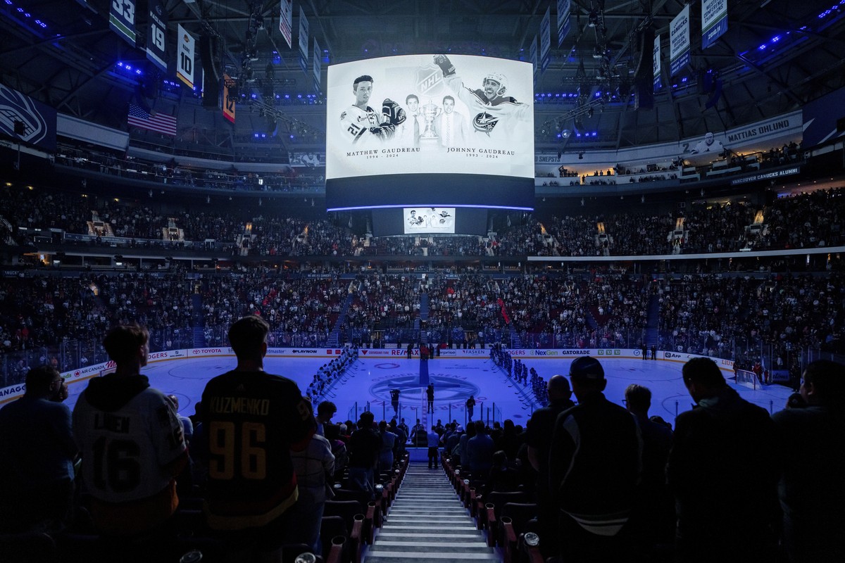 Fans and players stand for a moment of silence for Johnny and Matthew Gaudreau, who passed away last month, before a preseason NHL hockey game between the Vancouver Canucks and the Seattle Kraken in V ...
