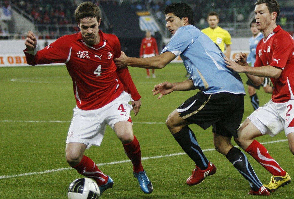 Swiss player Jonathan Rossini, left, fights for the ball with Uruguay's Luis Suarez, center, during a friendly test soccer match in the face of the 2010 soccer World Cup in South Africa between S ...