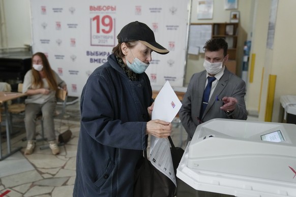 A woman casts her ballot at a polling station during a parliamentary elections in Moscow, Russia, Saturday, Sept. 18, 2021. Sunday will be the last of three days voting for a new parliament that is un ...