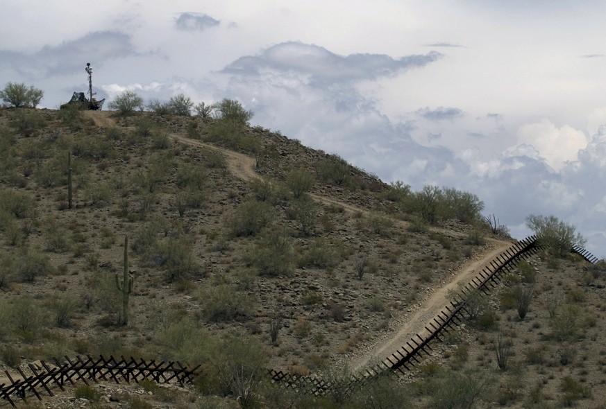 FILE - In this July 29, 2010, file photo, a U.S. National Guard vehicle guards covered under camouflage fabric sits atop a mountain next to the border fence near Sonoyta, Mexico. The U.S. National Gua ...