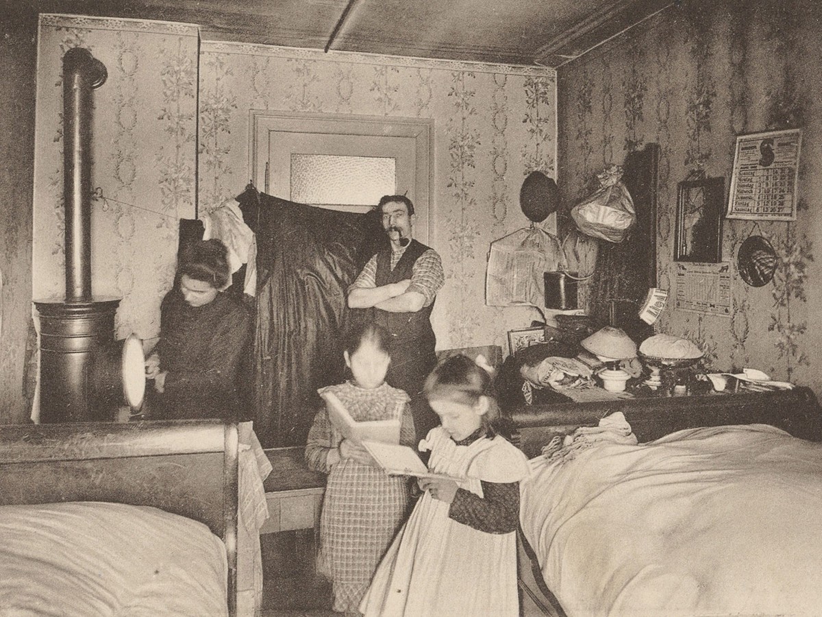 Cette famille zurichoise travaillant à domicile vit dans un espace particulièrement exigu, servant à la fois de cuisine, de salon et de chambre à coucher. Carte postale de l’exposition suisse sur le t ...