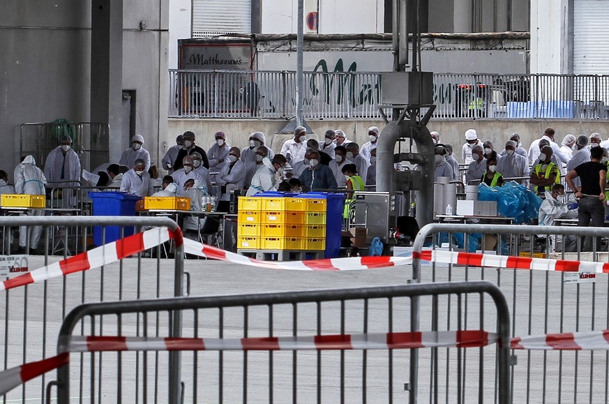 epa08498140 A handout photo made available by the German armed forces (Bundeswehr) shows soldiers taking coronavirus tests from workers at the Toennies meat factory in Rheda-Wiedenbrueck, western Germ ...