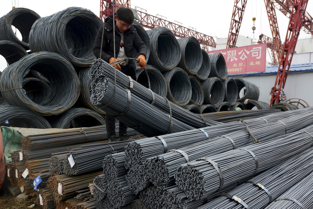 A worker loads steel products onto a vehicle at a steel market in Fuyang in central China's Anhui province Friday, March 2, 2018. China has expressed "grave concern" about a U.S. trade  ...