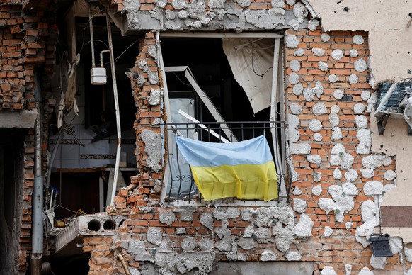 epa10016029 A Ukrainian national flag hangs from a balcony of a destroyed civilian building in Irpin, Ukraine, 16 June 2022. French President Emmanuel Macron, Italian Prime Minister Mario Draghi and G ...