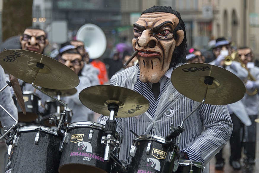 Die Guggenmusik &quot;Schlangefaenger&quot; am verregneten Cortege der &quot;Drey scheenschte Daeaeg&quot;, der Fasnacht, in Basel am Montag, 23. Februar, 2015. (KEYSTONE/Georgios Kefalas)