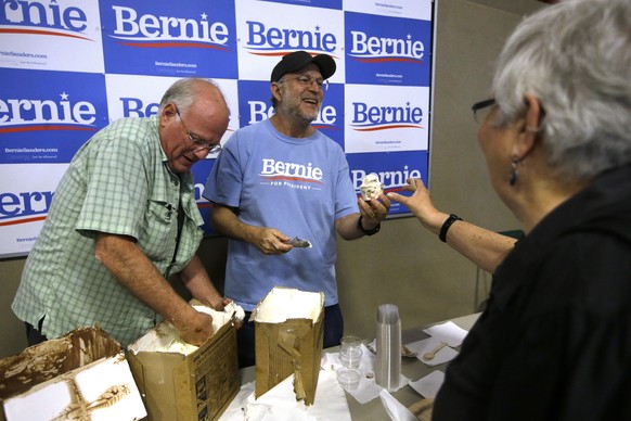 FILE - Ben &amp; Jerry&#039;s co-founder Ben Cohen, left, and fellow co-founder Jerry Greenfield, center, scoop ice cream before a campaign event for Sen. Bernie Sanders, I-Vt., not shown, Sept. 1, 20 ...