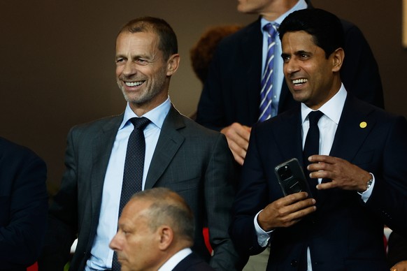 UEFA President Aleksander Ceferin, left, and Paris Saint-Germain Nasser Al-Khelaifi smile prior to the Champions League opening phase soccer match between Barcelona and Paris Saint-Germain at the Llui ...