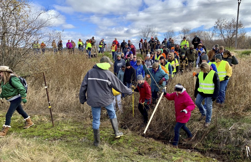 FILE - In this Oct. 23, 2018, file photo, volunteers cross a creek and barbed wire near Barron, Wis., on their way to a ground search for 13-year-old Jayme Closs who was discovered missing Oct. 15 aft ...