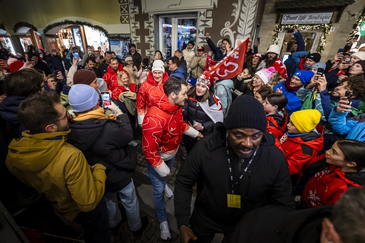 Loic Meillard of Switzerland, center right, Marco Odermatt of Switzerland, center, and Luca Aerni of Switzerland, center left, get welcomed at the House of Switzerland in the Bormio Bar at the 2026 Ol ...