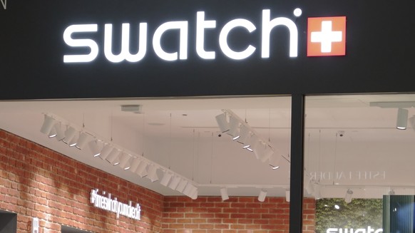 FILE - A man walk pass Swatch outlet at a shopping mall in Putrajaya, Malaysia, Thursday, Aug. 10, 2023. (AP Photo/Vincent Thian, File)