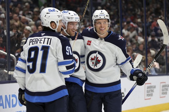Winnipeg Jets forward Nikolaj Ehlers, center, celebrates his second goal against the Columbus Blue Jackets with teammate forward Cole Perfetti, left, and forward Vladislav Namestnikov during the first ...