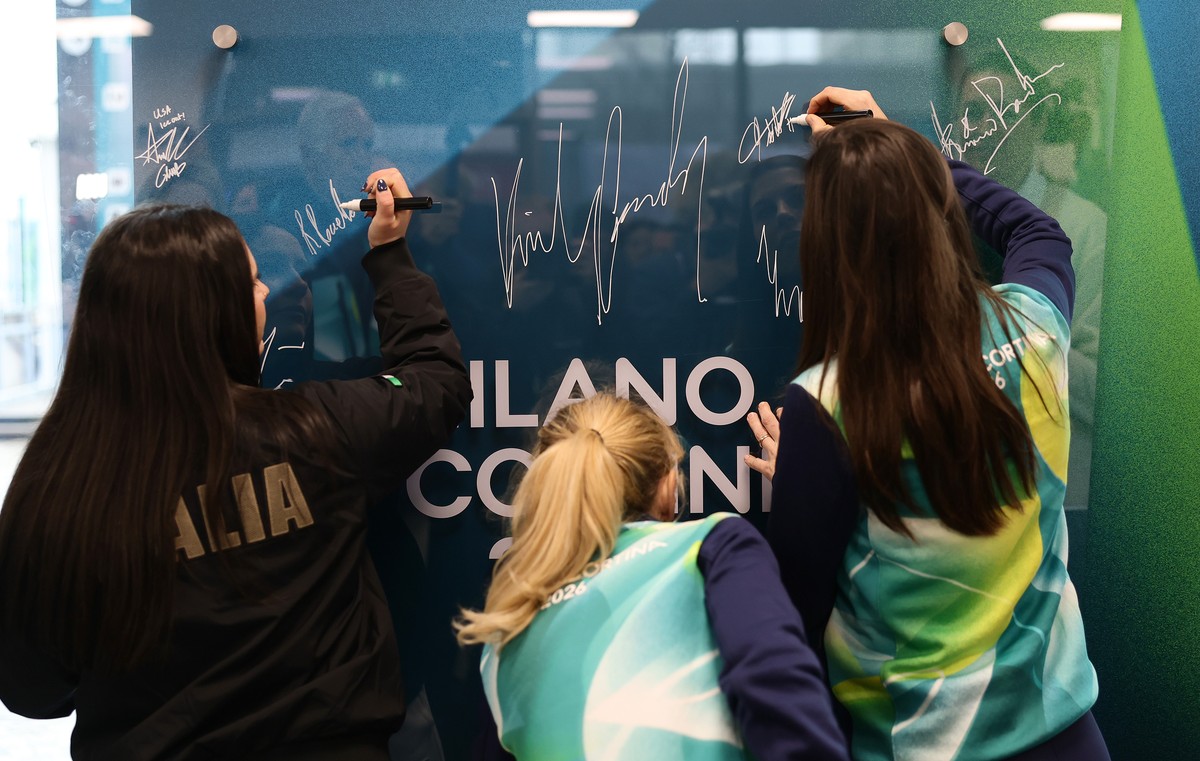 Athletes sign their autographs during the inauguration of the Olympic Truce Mural, at the Olympic Village, ahead of the 2026 Winter Olympics, in Milan, Italy, Monday, Feb. 2, 2026. (Andreas Rentz/Pool ...
