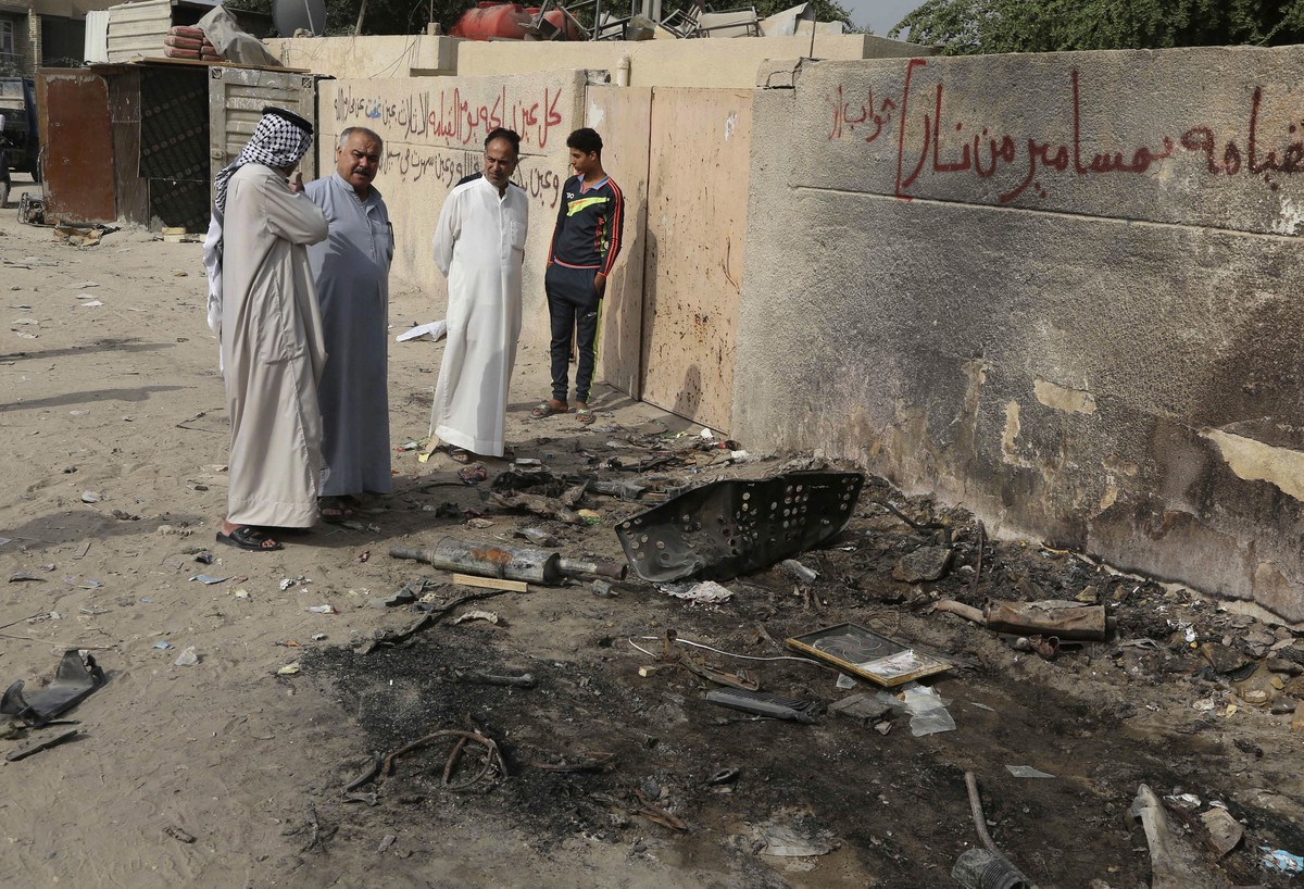 People inspect the aftermath of a deadly car bomb explosion that hit a popular fruit and vegetable market in a commercial street in Baghdad's northwestern neighborhood of Hurriyah, Iraq, Monday,  ...