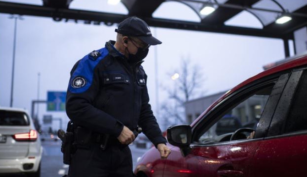 Un garde-frontière suisse contrôle les gens entrant dans le pays.