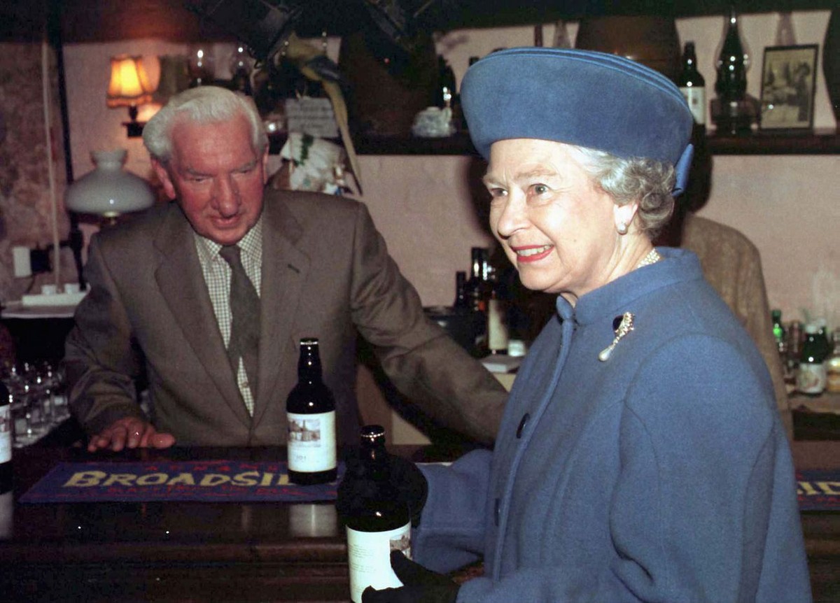 PAP98-19980327-TOPSHAM, DEVON, UNITED KINGDOM: Bottle of beer in hand, Britain's Queen Elizabeth II enjoys 27 MAR what is described as her first official visit to an English pub. She declined, ho ...