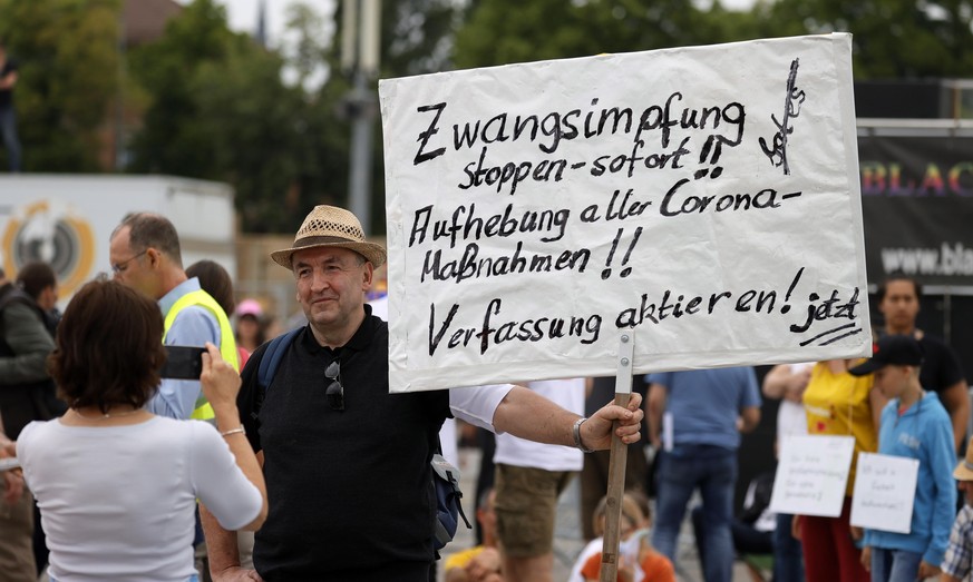 epa08412000 A man with a banner 'Stop compulsory vaccination immediately, cancel all corona measures' 'takes part in a demonstration of the initiative 'Lateral thinking' in Stuttgart, Germany, 09 May  ...