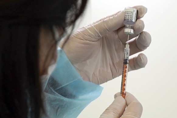 FILE - A health worker prepares a dose of the Pfizer COVID-19 vaccine in the complex of the Tokyo Skytree, Thursday, Jan. 6, 2022, in Sumida ward of Tokyo. On Friday, Sept. 6, 2023 The Associated Pres ...