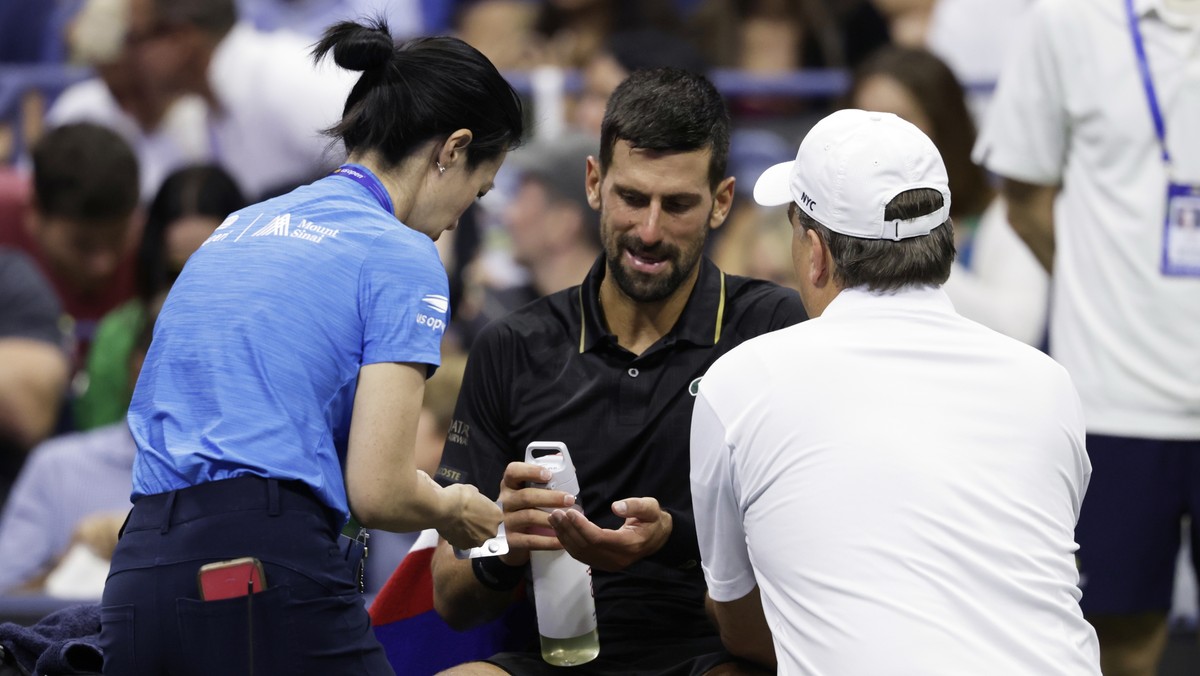 Novak Djokovic, of Serbia, talks with trainers during the third round match against Cameron Norrie, of Great Britain, of the U.S . Open tennis championships, Friday, Aug. 29, 2025, in New York. (AP Ph ...