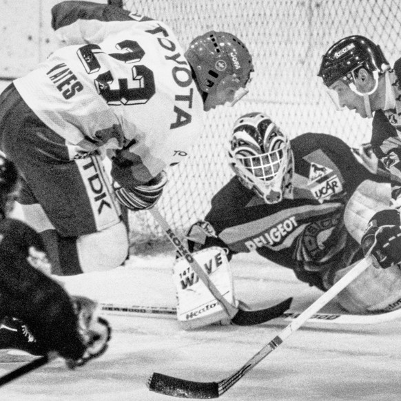 SCB-Goalie Renato Tosio, unterstuetzt vom Berner Roberto Triulzi, versucht einen Angriff des Kloteners Ross Yates, links abzuwehren, aufgenommen am 29. Februar 1992 in Kloten beim Meisterschaftsspiel  ...