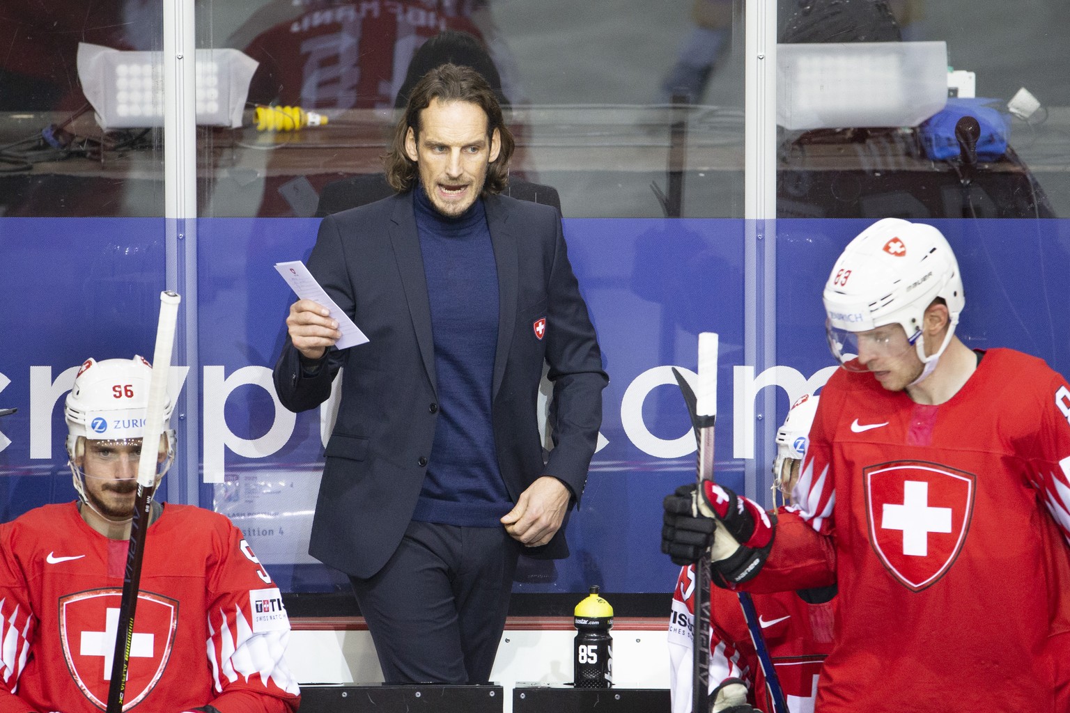 Patrick Fischer, head coach of Switzerland national ice hockey team, talks between Switzerland&#039;s forward Noah Rod, let, and Switzerland&#039;s forward Joel Vermin, right, during the IIHF 2021 Wor ...