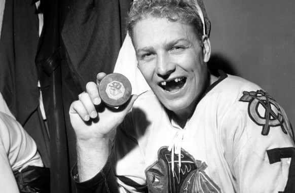 Bobby Hull of Chicago Blackhawks holds puck which he drove into New York Rangers&#039; net to score his 50th goal of the season and to tie the National Hockey League record in the final game of this r ...