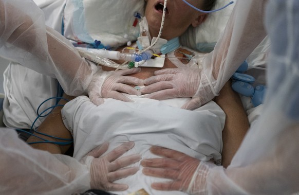 Nurses perform timed breathing exercises on a COVID-19 patient on a ventilator in the COVID-19 intensive care unit at the la Timone hospital in Marseille, southern France, Friday, Dec. 31, 2021. Paris ...