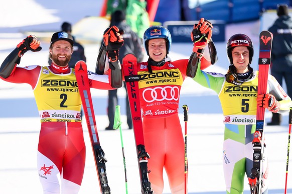 epa11035973 Second placed Marco Schwarz (L) of Austria, winner Marco Odermatt (C) of Switzerland and third placed Zan Kranjec (R) of Slovenia celebrate in the finish area after the Men&#039;s Giant Sl ...