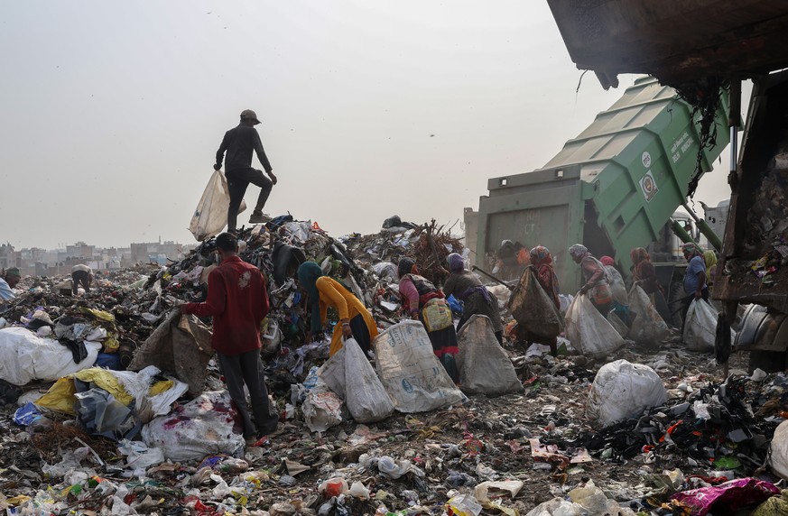 epa12156718 Waste collectors look for reusable items in waste dumped at a landfill in New Delhi, India, 05 June 2025. The Indian government launched a nationwide campaign titled ?One Nation, One Missi ...