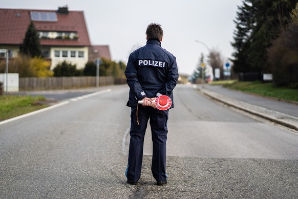 19.03.2020, Bayern, Mitterteich: Ein Polizist kontrolliert die Ortsein- und ausfahrt von Mitterteich. Das Landratsamt in Tirschenreuth erteilte am Mittwochabend eine Ausgangssperre, weil in Mitterteic ...