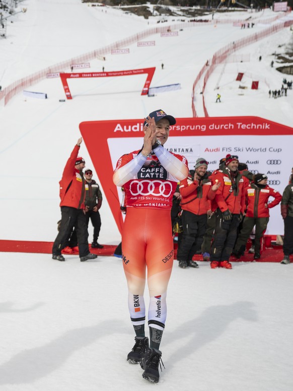 Winner Franjo von Allmen of Switzerland, third placed Alexis Monney of Switzerland, and second placed Marco Odermatt of Switzerland, from left, celebrate in the finish area after the men's Downhi ...